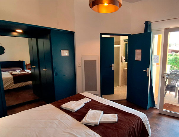 Chambre double du Relais du Moulin Neuf à Barbaste avec salle de bain privative et accès direct à la terrasse.